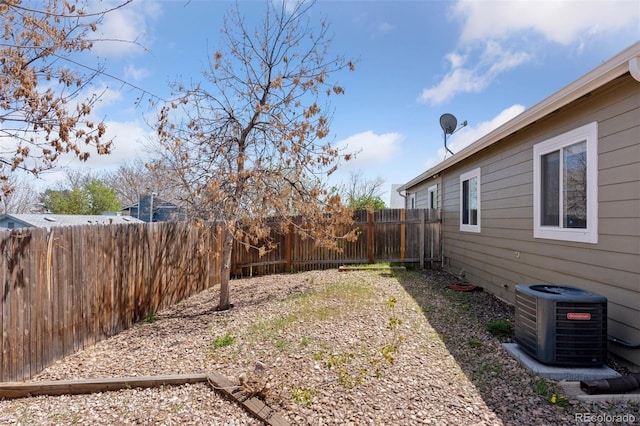 view of yard with central AC and a fenced backyard