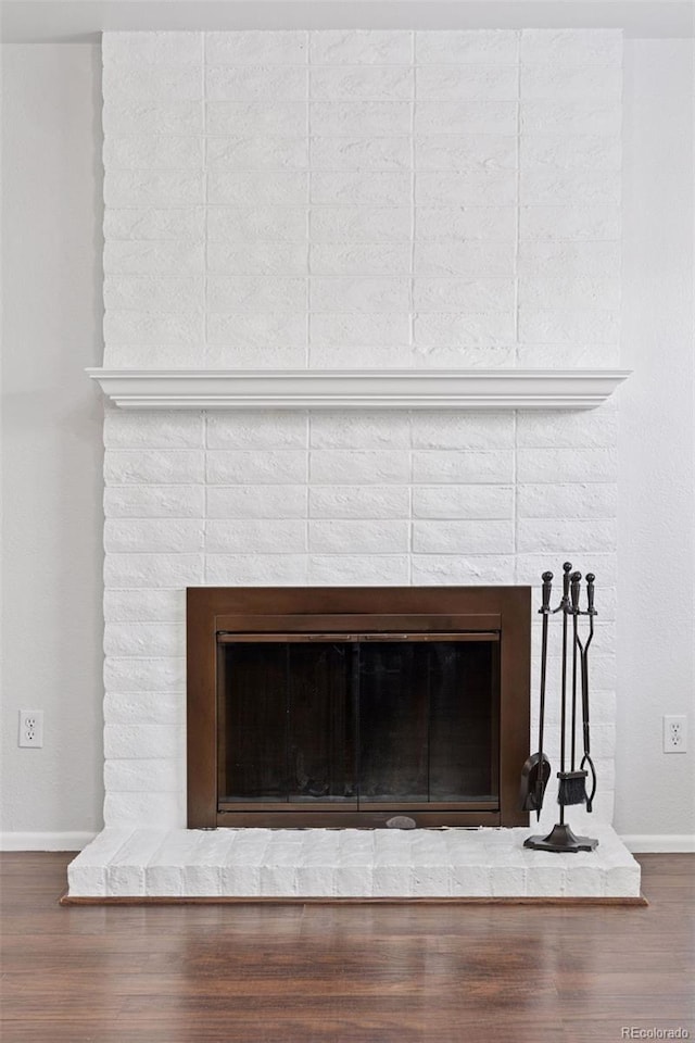 details with a brick fireplace, baseboards, and wood finished floors