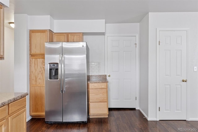 kitchen with light brown cabinetry, baseboards, dark wood-style flooring, and stainless steel refrigerator with ice dispenser