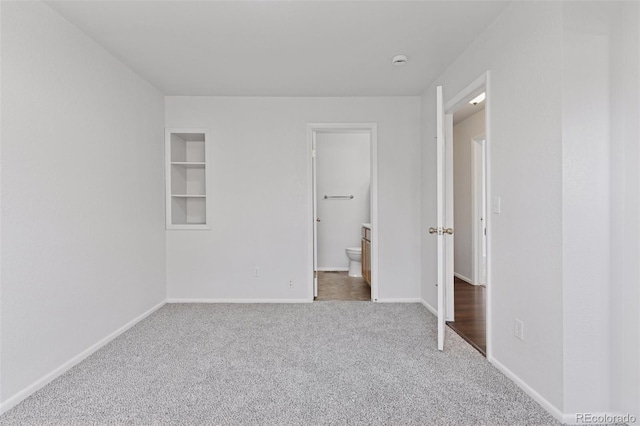 unfurnished bedroom with baseboards, carpet, and ensuite bath