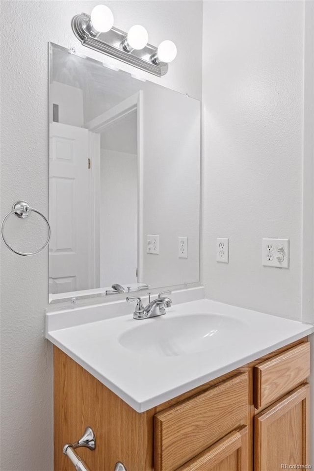 bathroom with vanity and a textured wall