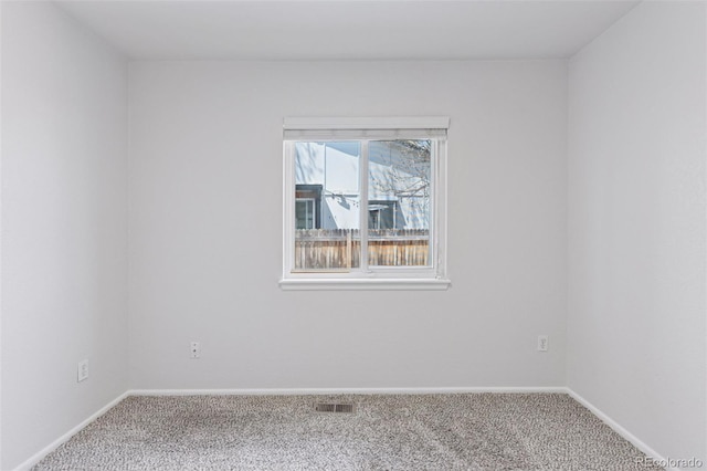 spare room featuring baseboards, carpet flooring, and visible vents