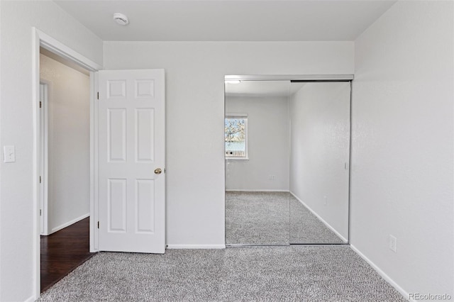 unfurnished bedroom with a closet, baseboards, and carpet flooring