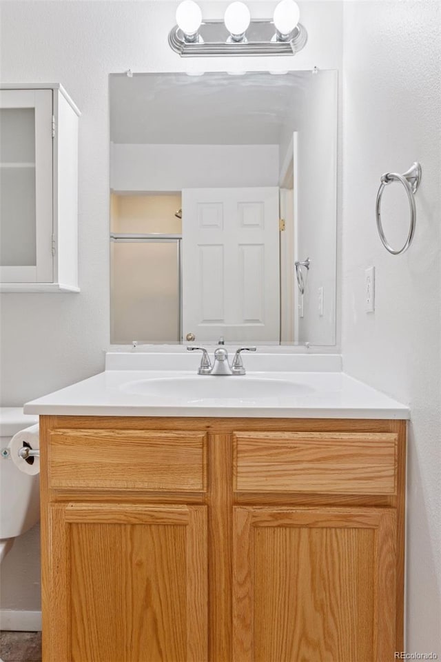 bathroom with vanity, a shower, and toilet
