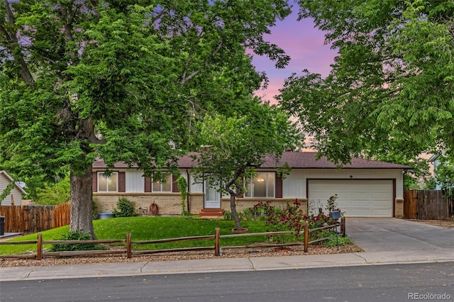 16839 E Amherst Ave E, Aurora, CO 80013 - view of front of house featuring brick siding, a fenced front yard, an attached garage, and driveway