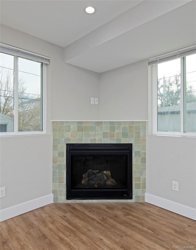 interior details with hardwood / wood-style flooring and a tile fireplace