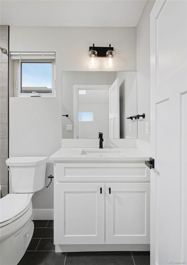 bathroom with toilet, tile patterned flooring, and vanity