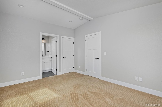 interior space with carpet floors and vaulted ceiling with beams