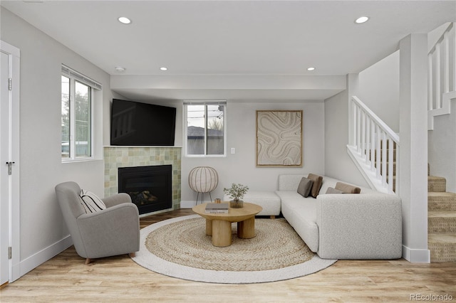 living room with light hardwood / wood-style floors and a tiled fireplace