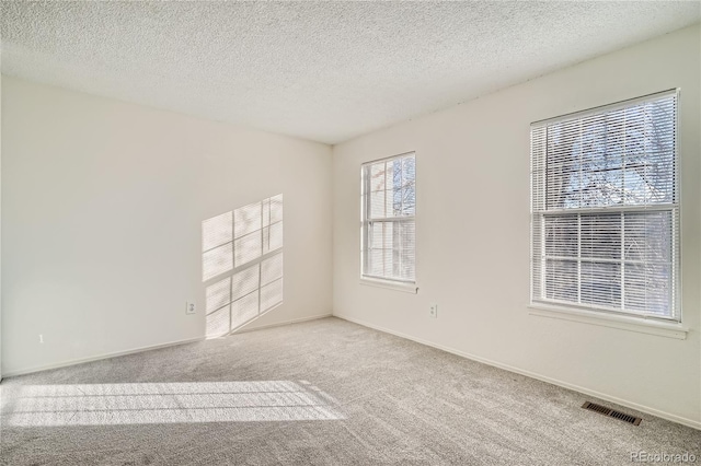 carpeted empty room with a textured ceiling