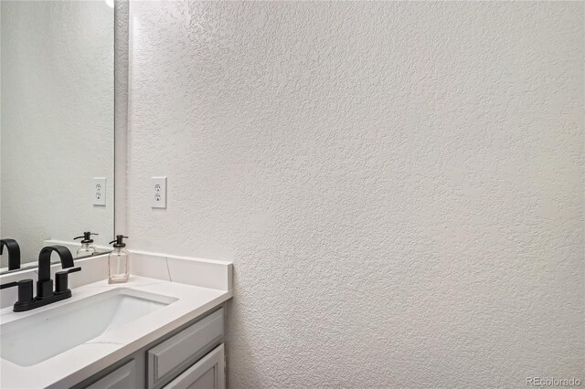 bathroom featuring a textured wall and vanity