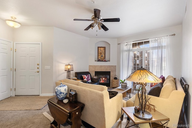 carpeted living room featuring ceiling fan and a tile fireplace