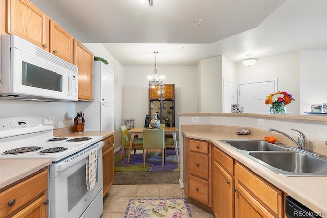 kitchen with sink, a chandelier, hanging light fixtures, light tile patterned floors, and white appliances