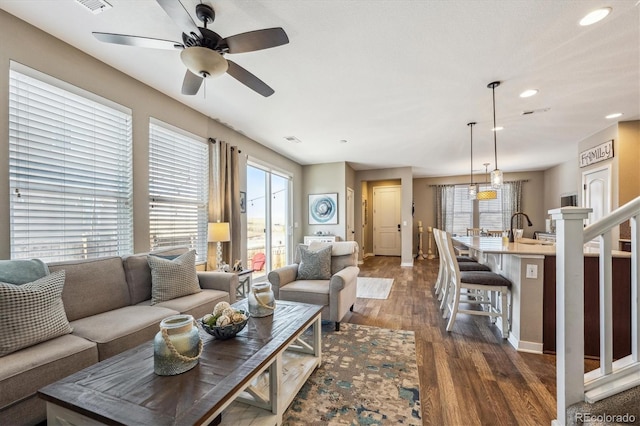 living room featuring sink, dark hardwood / wood-style floors, and ceiling fan