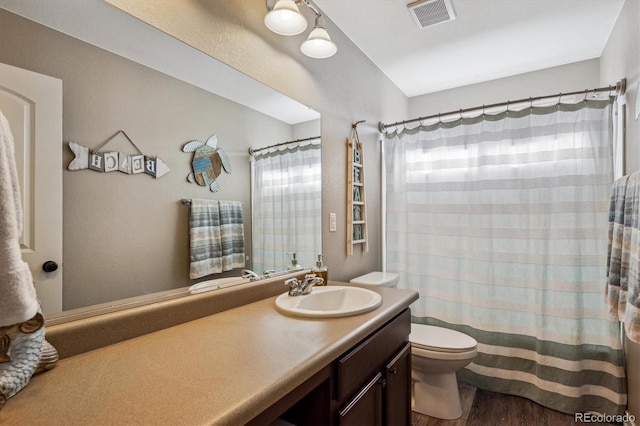 bathroom with hardwood / wood-style flooring, vanity, and toilet