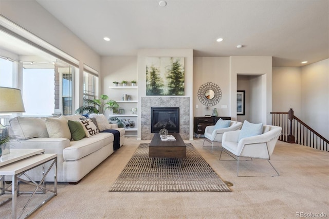 living area featuring built in features, a fireplace, recessed lighting, and light colored carpet