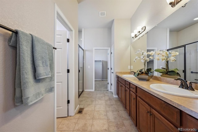full bath with visible vents, a sink, double vanity, and a stall shower
