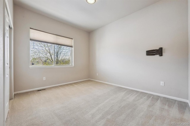 carpeted spare room featuring visible vents and baseboards