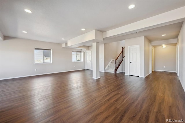 unfurnished living room featuring stairway, baseboards, dark wood-type flooring, and recessed lighting