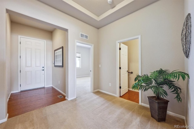 carpeted foyer entrance featuring baseboards and visible vents