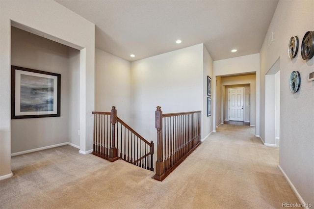 hall featuring recessed lighting, baseboards, carpet, and an upstairs landing