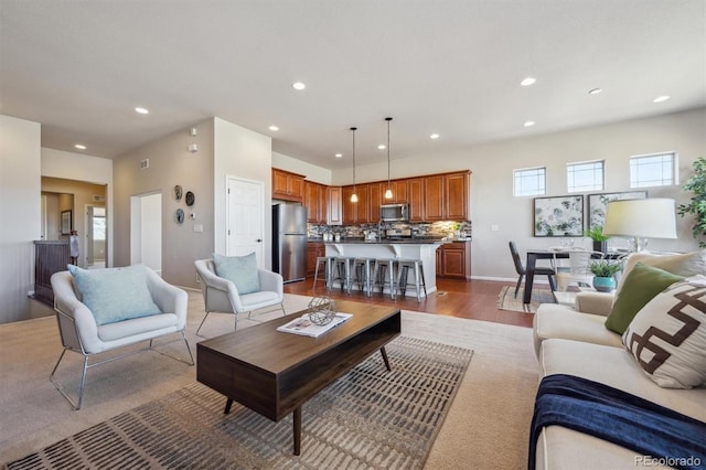living room with baseboards, visible vents, light wood finished floors, and recessed lighting