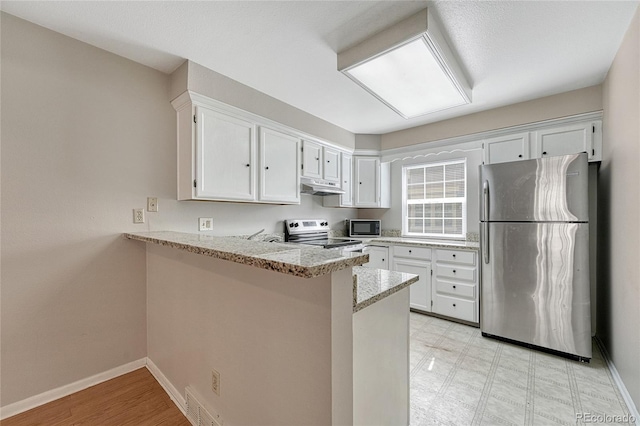 kitchen with under cabinet range hood, light floors, appliances with stainless steel finishes, a peninsula, and white cabinets