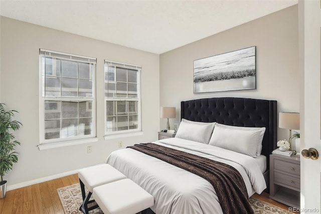 bedroom with wood finished floors and baseboards