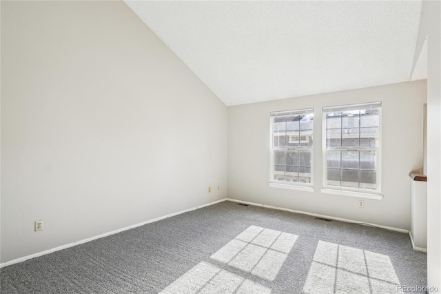 carpeted empty room with visible vents, baseboards, and vaulted ceiling