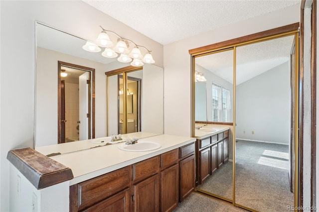 bathroom featuring vanity, lofted ceiling, baseboards, and a textured ceiling