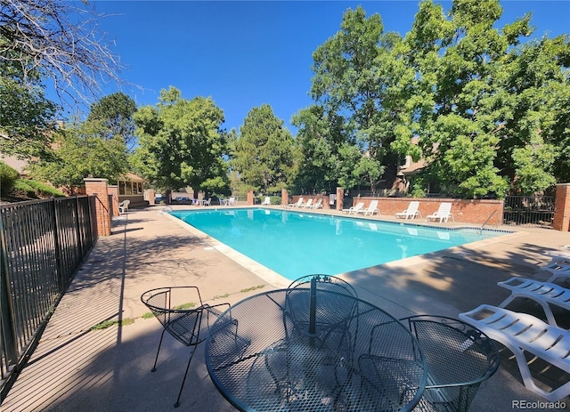 pool with a patio and fence