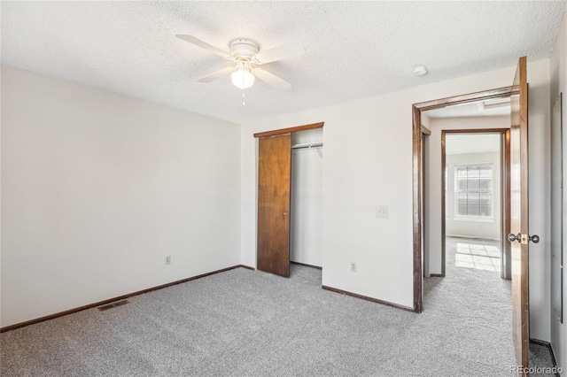 unfurnished bedroom with baseboards, a textured ceiling, visible vents, and carpet