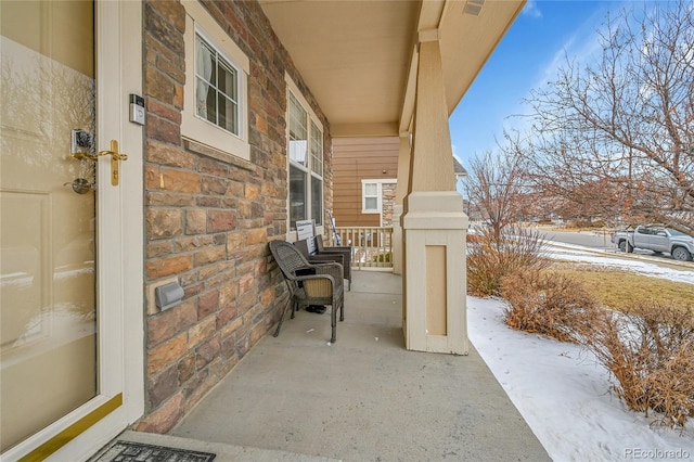 snow covered patio featuring covered porch