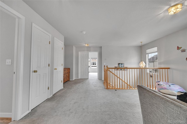 hallway featuring light colored carpet