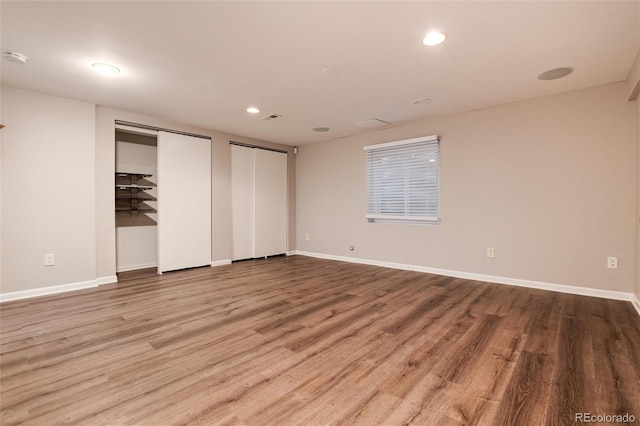 unfurnished bedroom with multiple closets and light hardwood / wood-style flooring