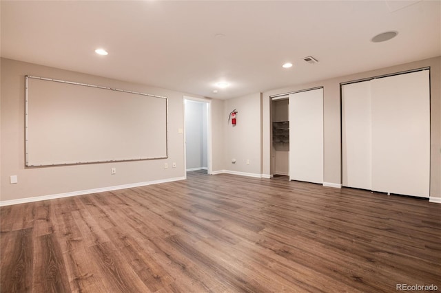 unfurnished bedroom with multiple closets and wood-type flooring