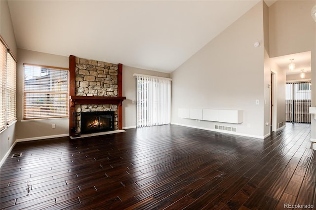 unfurnished living room with dark wood-type flooring, high vaulted ceiling, and a fireplace