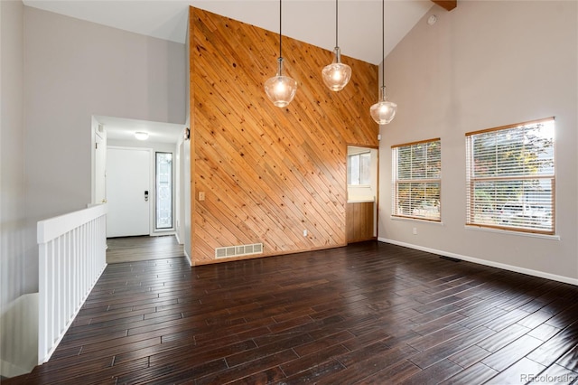 interior space with high vaulted ceiling, wooden walls, and dark hardwood / wood-style floors