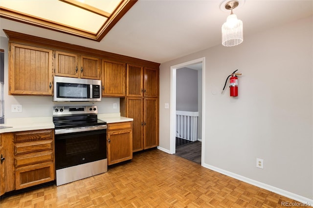 kitchen featuring light parquet floors, pendant lighting, and stainless steel appliances