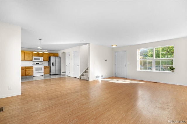 18897 E Linvale Pl, Aurora, CO 80013 - unfurnished living room featuring stairs, light wood-style floors, baseboards, and a chandelier