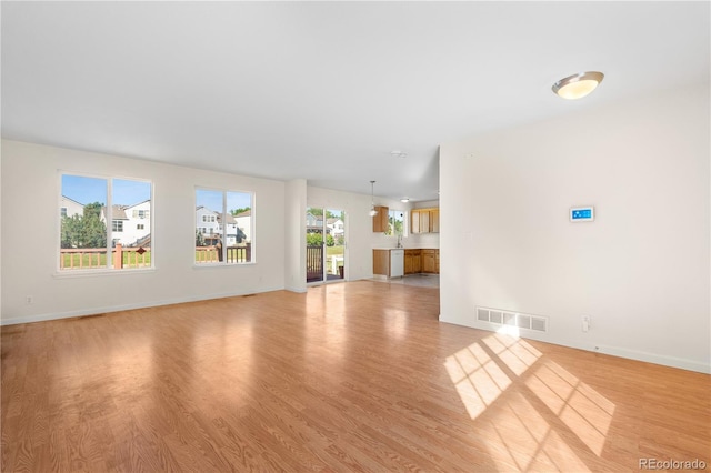 18897 E Linvale Pl, Aurora, CO 80013 - unfurnished living room featuring light wood-type flooring and baseboards