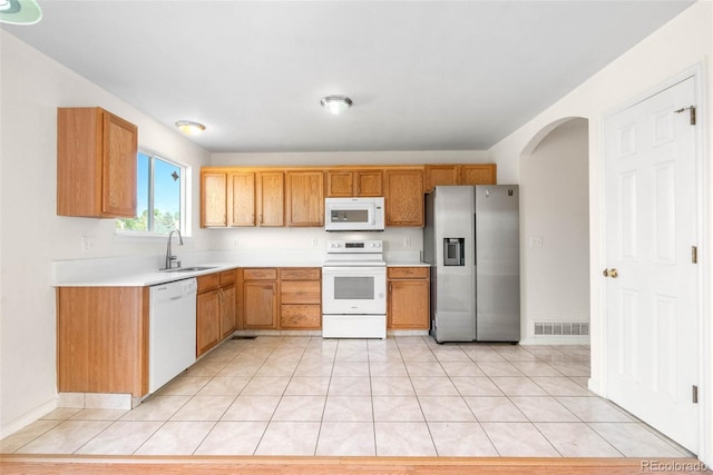 18897 E Linvale Pl, Aurora, CO 80013 - kitchen featuring white appliances, arched walkways, light countertops, light tile patterned flooring, and a sink