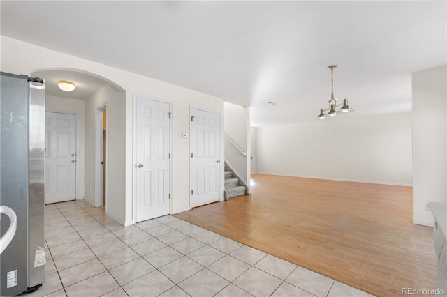 18897 E Linvale Pl, Aurora, CO 80013 - spare room featuring light tile patterned floors, arched walkways, stairs, and baseboards