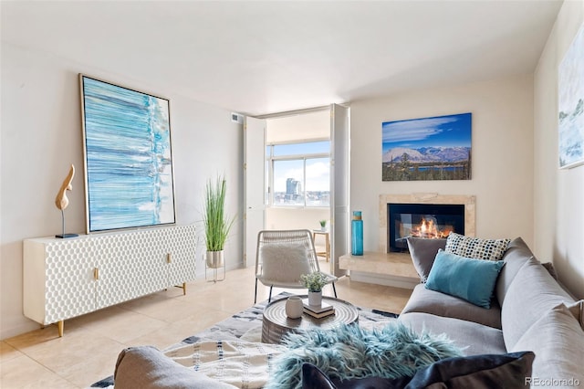 living room featuring visible vents, light tile patterned flooring, and a fireplace