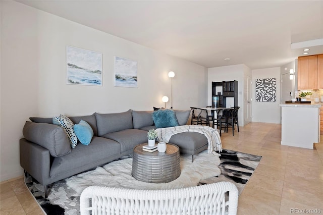 living area featuring light tile patterned floors and baseboards