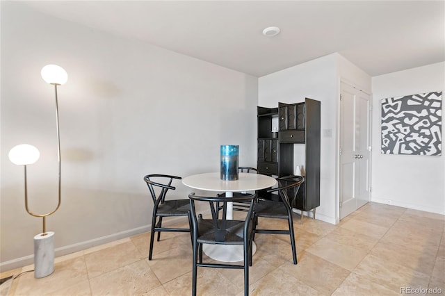 dining area with light tile patterned floors and baseboards