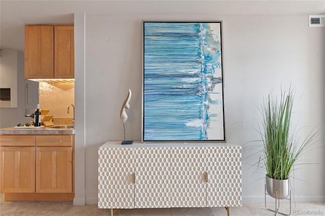 interior space with visible vents, baseboards, radiator heating unit, light tile patterned flooring, and a sink