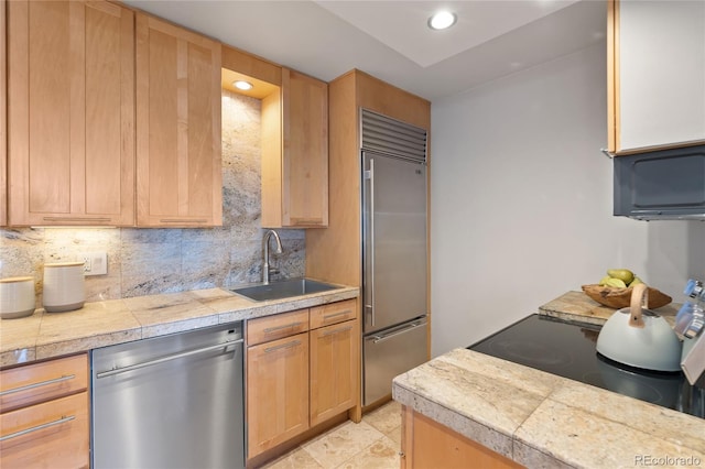 kitchen with a sink, tile countertops, stainless steel appliances, recessed lighting, and decorative backsplash