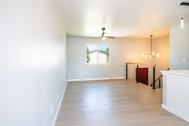 10932 W 107th Ave, Broomfield, CO 80021 - empty room featuring light wood-style floors, a ceiling fan, and a chandelier