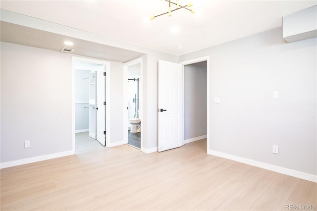 10932 W 107th Ave, Broomfield, CO 80021 - unfurnished bedroom with light wood-style flooring, a walk in closet, a chandelier, ensuite bath, and a closet